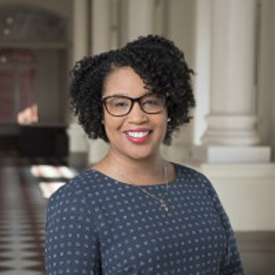 denisha porter a person with dark hair and a blue dot shirt in a building with columns